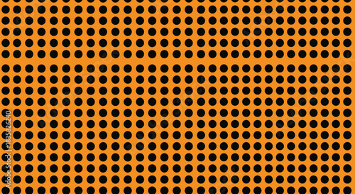 Close-up view of an orange surface with a regular grid pattern of black oval perforations.
