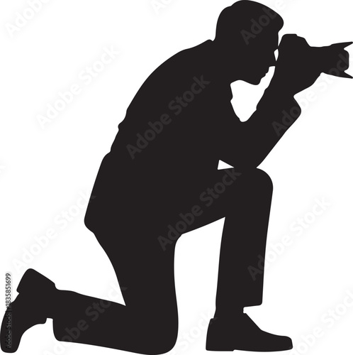 Silhouette of a man kneeling and taking a photograph with a D S L R camera photographer
