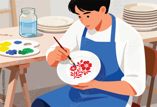 A person in a blue apron paints floral designs on a white plate with a brush, with palettes, water jar, and plates