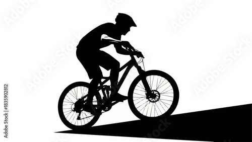 Silhouette of a mountain biker riding downhill on a trail.