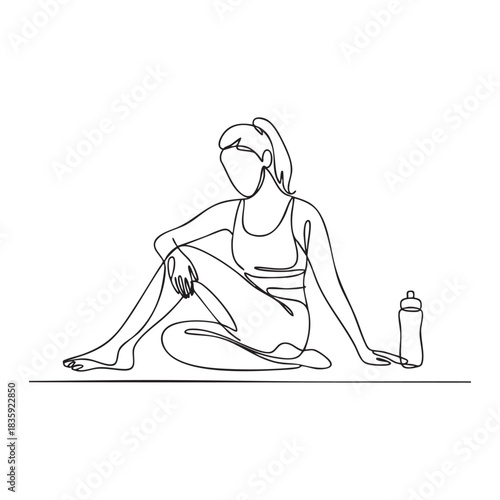 Woman in athletic wear sitting on yoga mat with water bottle fitness exercise