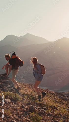 Slow motion shot of young couple hiking uphill at golden hour chatting laughing travel content
