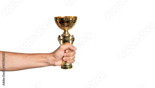 Hand holding a golden trophy cup with ornate design, fingers gripping the base, arm visible on the left side pure white background cutout