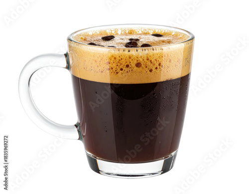 A clear glass mug filled with dark coffee, topped with foam and coffee beans, isolated on black