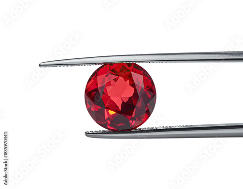 A faceted, round gemstone is held by tweezers against a black background, reflecting light