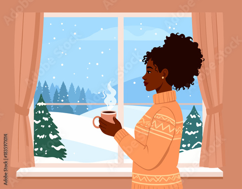 A woman in a sweater holds a steaming mug, gazing out a window at a snowy winter landscape with trees and falling snow.