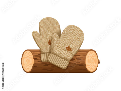 Cozy pair of beige knitted winter mitten with maple leaf on wood log. This warm handwear accessory for cold autumn weather evokes feeling of comfort and warmth