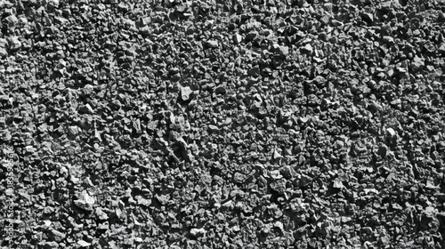 A grayscale highly textured image depicting a close up view of rough dark ground