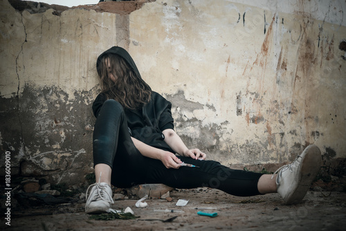 Addict with syringe wants to do an injection into a vein while in the old dirty crack house. female drug addict uses drugs. The social problem of drug addiction in young people.