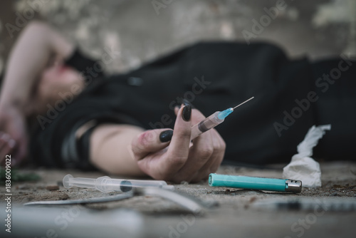 Addict with syringe wants to do an injection into a vein while in dirty crack house. female drug addict uses drugs. The social problem of drug addiction in young people.  