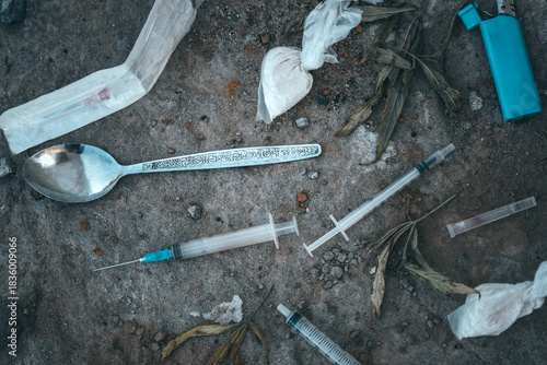 Foto Top view flat lay of various items used by drug addicts, including syringes, spoons, lighters, and powders like heroin and cocaine, depicting the dangerous reality of substance abuse
