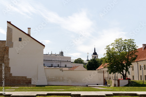 Beautiful city streets on a sunny summer day. Historic buildings among green trees in European city. 1 June 2025, Vilnius, Lithuania