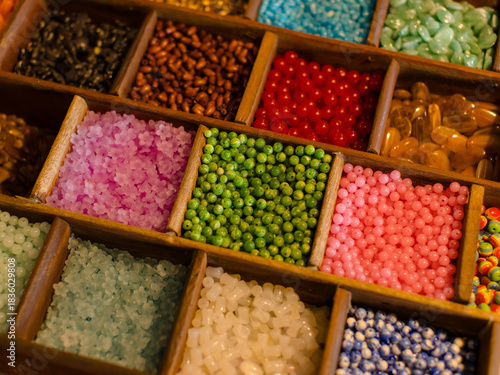 Fotografia Vibrant collection multicolor craft beads neatly arrange in wooden organizer boxes compartment showcases unique textures hues, handcrafted creating charming slow fashion bracelets inspiring display