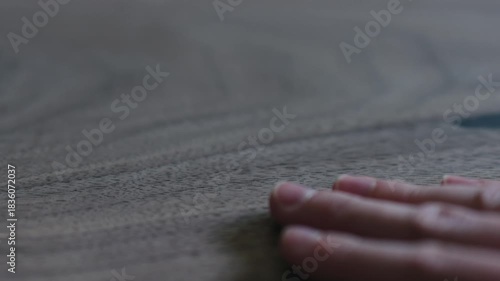 Slow motion slide shot of man hand checking untrated black walnut solid board