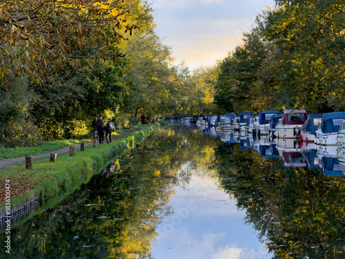 Valokuva River Wey Navigation with moored boats and people enjoying the towpath on a calm