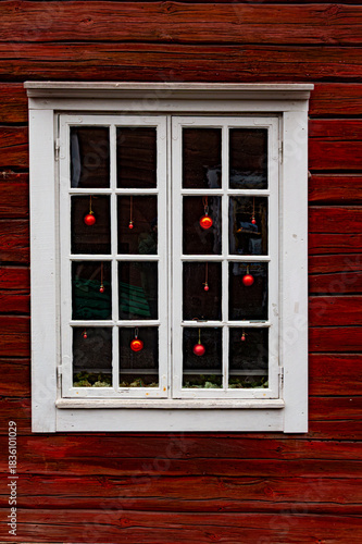 Old window on a wooden house with christmas decoratuions.