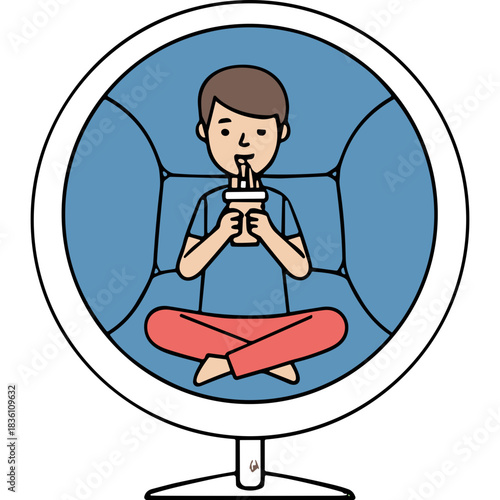 Young Man Relaxing Sitting Cross Legged On A Blue Couch Drinking From A Cup With A Straw A Casual And Comfortable Scene Of Leisure Time At Home
