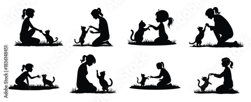 Black silhouettes of girls playing with cats on grass