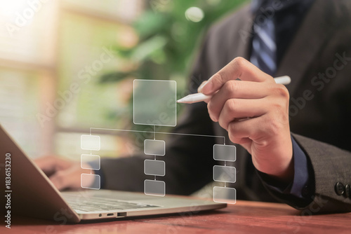 A businessman designs a digital project chart on a laptop. Concept of process management, workflow planning, and algorithm flow system. corporate structure, business flowchart automation