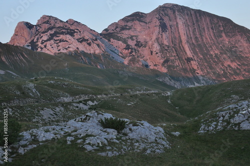Breathtaking mountain landscape at dusk showcases rugged terrain and colorful sky over natural scenery