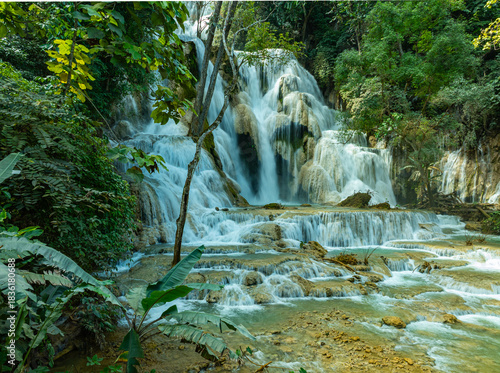 Aerial view of Tat Kuang Si Falls is a stunning, multi-tiered waterfall near Luang Prabang, Laos, famous for its vibrant turquoise pools and jungle setting. it is a popular day trip.