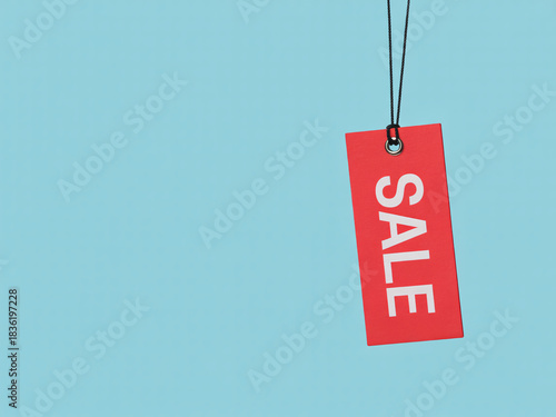 Vibrant red sale tag hangs against a clean blue backdrop creating an eye-catching announcement for your next big promotion