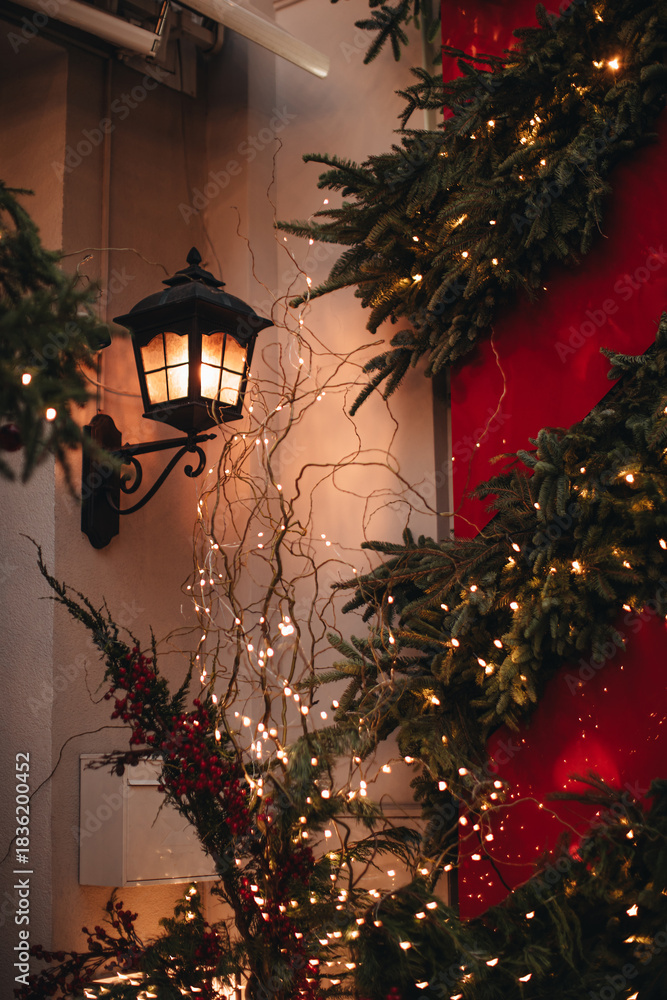 Fototapeta premium Christmas New Year's magic outdoor decorations, street decorated with golden lights, burning lantern, garlands on Christmas trees, the atmosphere of winter holiday celebration