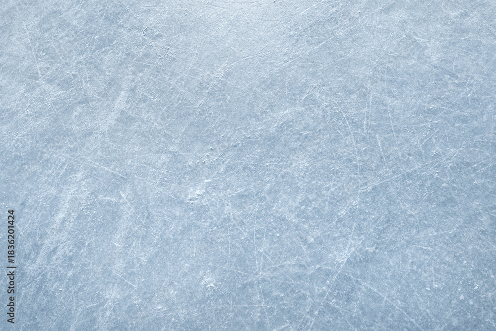 Fototapeta premium An ice surface as an ice rink with ice skates tracks. Winter sports texture. Poster with copy space.