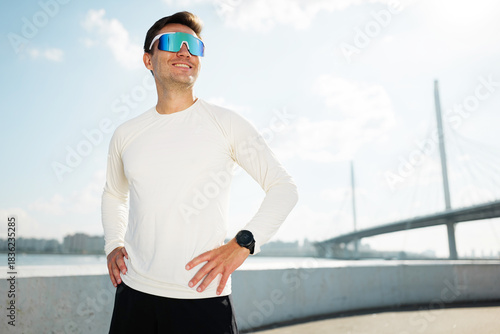 Man enjoys outdoor workout near a bridge by the river