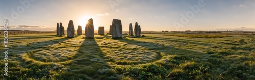 Sunrise over ancient stone circle in tranquil countryside setting