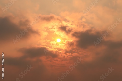 Sun setting behind warm orange clouds
