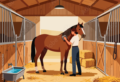 A person grooming a brown horse in a stable. Hay bales and water tub are also present
