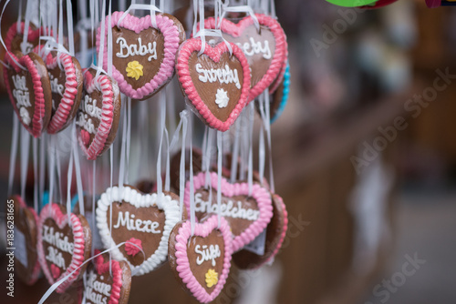Christmas tree decorations.Assortment of traditional German gingerbread hearts (Lebkuchenherzen) hanging on ribbons. Close-up view of colorful holiday sweets with frosted messages