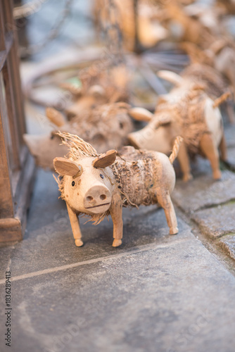Reindeer in the snow.Close-up of a whimsical, handcrafted wooden pig figurine with straw accents. Traditional Christmas or lucky charm souvenir at the German market