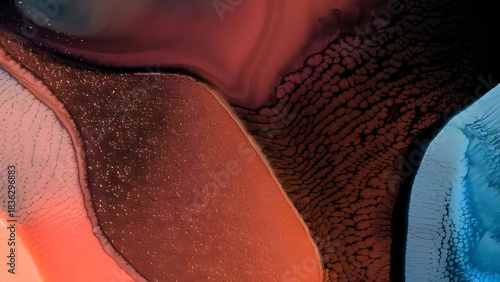 Abstract macro photography captures swirling organic forms in vibrant hues of orange red and blue with subtle shimmering textures