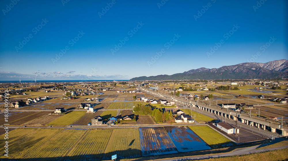 Obraz premium 北アルプスは雪化粧をしている12月上旬の日本の富山県東部にある黒部川扇状地