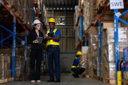 Fotografi Warehouse supervisor and worker using digital tablets to review logistics data while another staff scans package