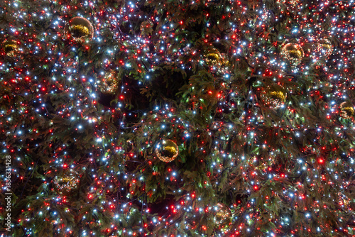 Festive dark theme with red background decorated with Christmas lighting, balls, green Christmas trees with garlands, December holidays in England