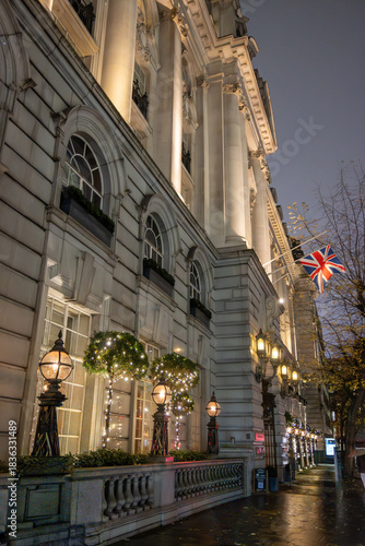 Walking on streets of Central London in Covent Garden decorated with Christmas lighting and green Christmas trees with garlands, December holidays in England
