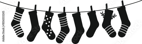 Festive christmas stockings hanging on a line in black and white silhouette