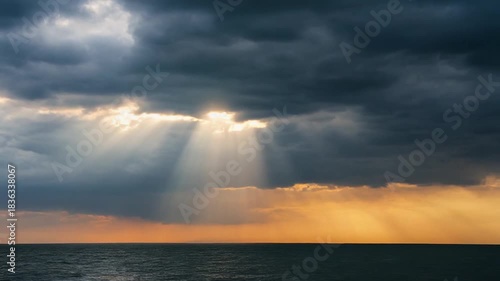 Dramatic sky with sunbeams shining through the dark clouds