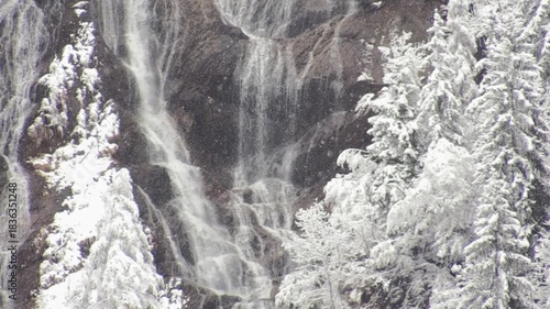 Winter Waterfall Flowing Through Snowy Alpine Forest, Italian Alps