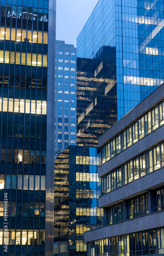 Obraz premium Office building facade with illuminated windows in morning light