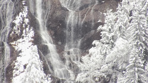 Winter Waterfall Flowing Through Snowy Alpine Forest, Italian Alps