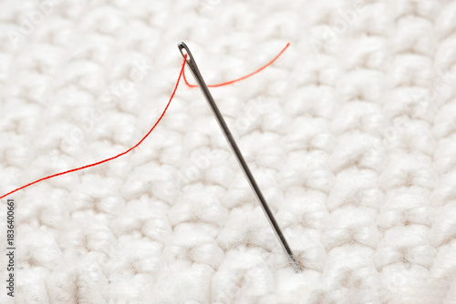 Close-up of a needle with red thread