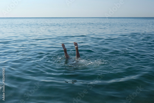 The feet of a drowning child sticking out of the water