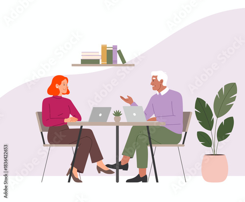 This image captures a friendly business meeting between two colleagues with laptops, highlighting collaboration, discussion, and the importance of teamwork in a modern workplace.