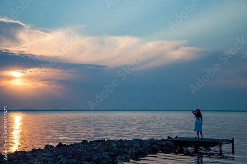 Romantic woman sunset sea beach in summer. Woman at sea sunrise. Sunset beach and sky with seascape. Summer sea beach sunrise. Girl at romantic sunset horizon. Silhouette girl sunrise. Burning dusk