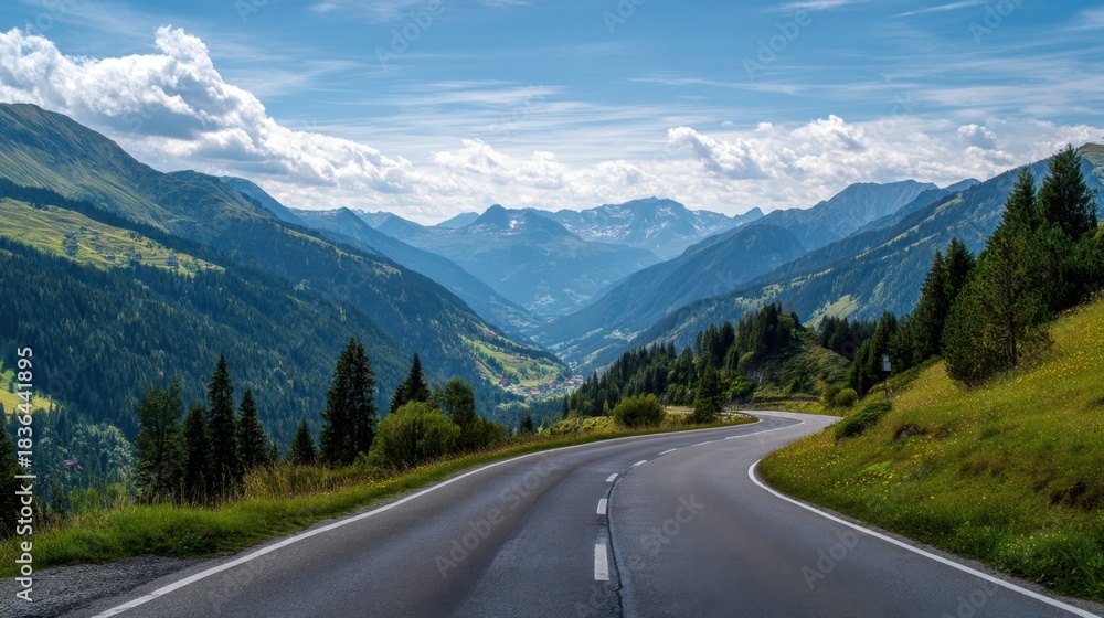Fototapeta premium A long road with a mountain range in the background. The road is empty and the sky is clear