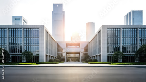 Modern corporate headquarters building facade with glass windows and symmetrical architecture, set against a bright, sunlit urban skyline featuring tall skyscrapers in the background